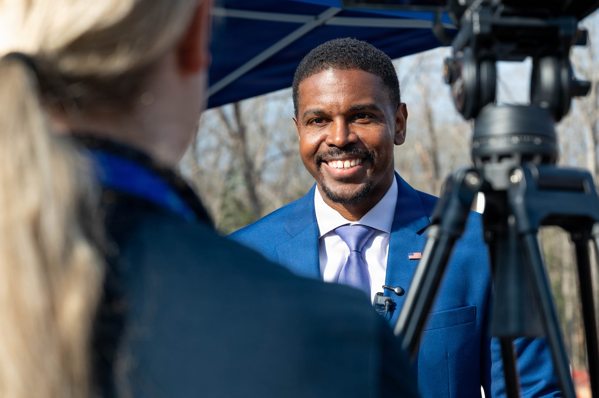 Phillip Jones, mayor of Newport News stands in front of a camera and an interviewer smiling.