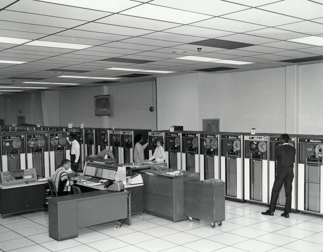 Data-processing personnel operate three IBM 7080 computers