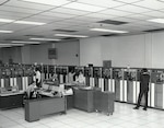 Data-processing personnel operate three IBM 7080 computers