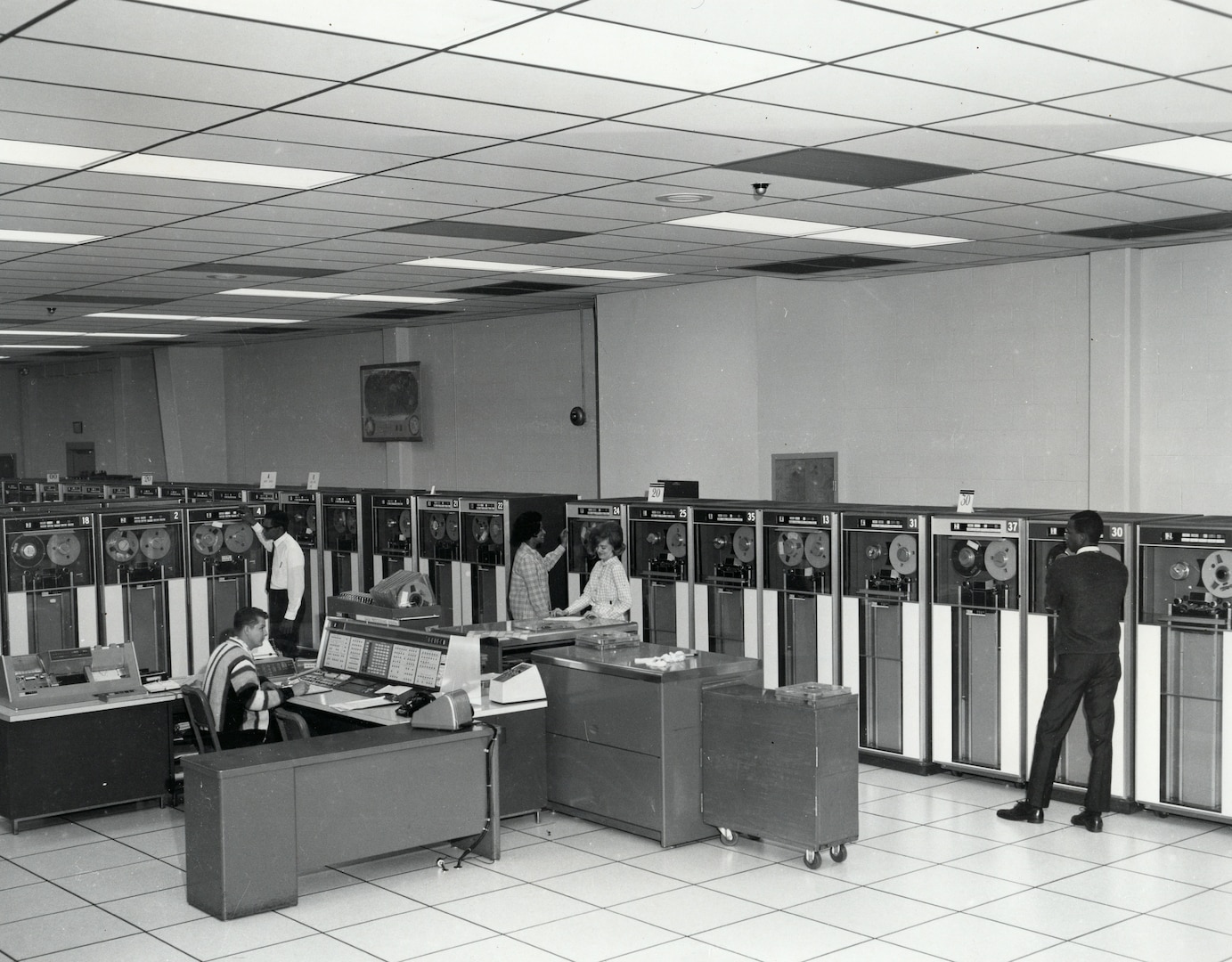 Data-processing personnel operate three IBM 7080 computers