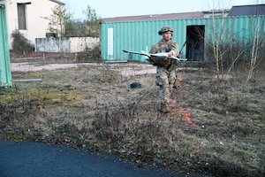U.S. Air Force Staff Sgt. Yin Pu, 432nd Civil Engineer Squadron, moves a simulated drone during an Explosive Ordnance Disposal exercise during Silver Flag March 10, 2026, at Ramstein Air Base, Germany. Silver Flag covered a wide range of critical skills, including airfield damage repair, response to chemical, biological, radiological, and nuclear threats, lodging operations, and mortuary affairs. This iteration was also the first time the force support career field rejoined their civil engineer and logistics readiness counterparts in three years. (U.S. Air Force photo by Capt. Amber R. Kelly-Herard)