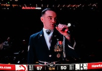 A jumbotron shows U.S. Air Force Staff Sgt. William Douglass, a ceremonial guardsman assigned to the U.S. Air Force Honor Guard Drill Team, while he emcees a Drill Team performance during an NBA halftime show in Atlanta, Ga., March 12, 2026. During the event the Drill Team performed in front of approximately 16,000 guests and emphasized the team mission of connecting with audiences and inspiring the next generation of service members through precision and excellence. (U.S. Air Force photo by Tech. Sgt. Sergio A. Gamboa)