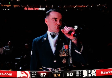 A jumbotron shows U.S. Air Force Staff Sgt. William Douglass, a ceremonial guardsman assigned to the U.S. Air Force Honor Guard Drill Team, while he emcees a Drill Team performance during an NBA halftime show in Atlanta, Ga., March 12, 2026. During the event the Drill Team performed in front of approximately 16,000 guests and emphasized the team mission of connecting with audiences and inspiring the next generation of service members through precision and excellence. (U.S. Air Force photo by Tech. Sgt. Sergio A. Gamboa)