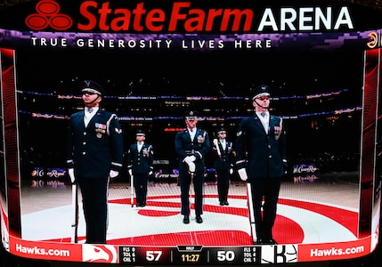 A jumbotron shows the U.S. Air Force Honor Guard Drill Team as they perform during an NBA halftime show in Atlanta, Ga., March 12, 2026. During the event the Drill Team performed in front of approximately 16,000 guests and emphasized the team mission of connecting with audiences and inspiring the next generation of service members through precision and excellence. (U.S. Air Force photo by Tech. Sgt. Sergio A. Gamboa)