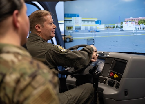 U.S. Air Force Col. Richard Kind, 97th Air Mobility Wing commander, operates a Driving Simulator at Altus Air Force Base, Oklahoma, Feb. 25, 2026. Guided by members of the 97th Logistics Readiness Squadron, Kind simulated driving a variety of vehicle types, in different scenarios and shifting procedures. (U.S. Air Force photo by Airman 1st Class Emma Wright)