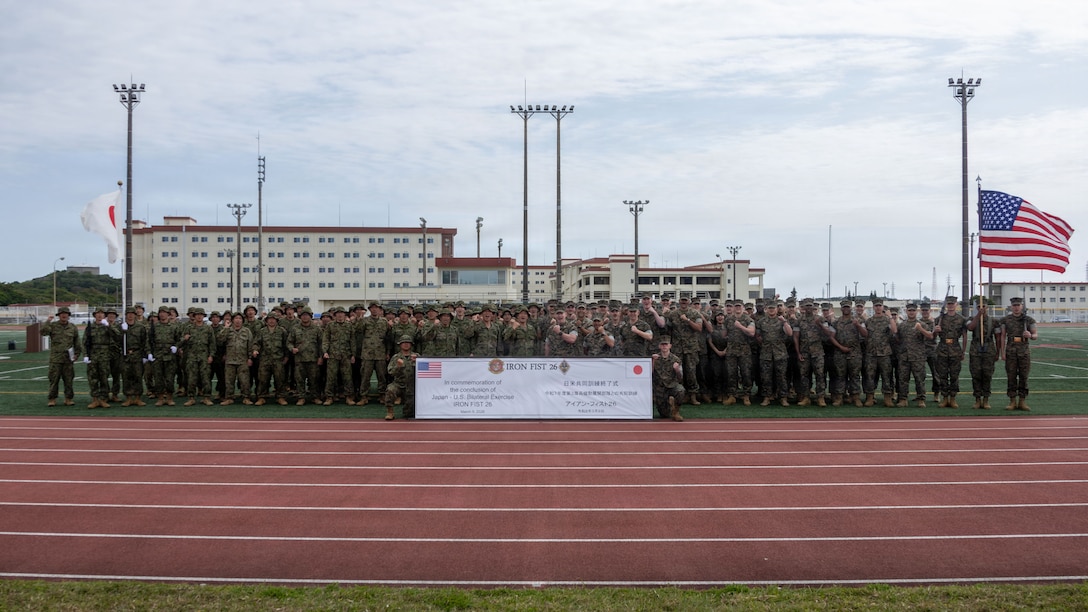 U.S. Marines and Sailors with the 31st Marine Expeditionary Unit, and Japan Ground Self-Defense Force members, pose for a photo in the closing ceremony for Iron Fist 26, at Camp Hansen, Okinawa, Japan, March 9, 2026. Iron Fist is an annual bilateral exercise designed to increase interoperability and strengthen the relationships between the U.S Marine Corps, U.S. Navy and JGSDF. The 31st MEU is a persistent, combat credible force operating aboard the ships of the Tripoli Amphibious Ready Group in the U.S. 7th fleet area of operations, routinely interacting and operating with our allies and partners to contribute to deterrence, security, crisis response, and combat operations in the Indo-Pacific region. (U.S. Marine Corps photo by Cpl. Eric Reyes)