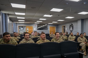 Airmen sit down in a class.