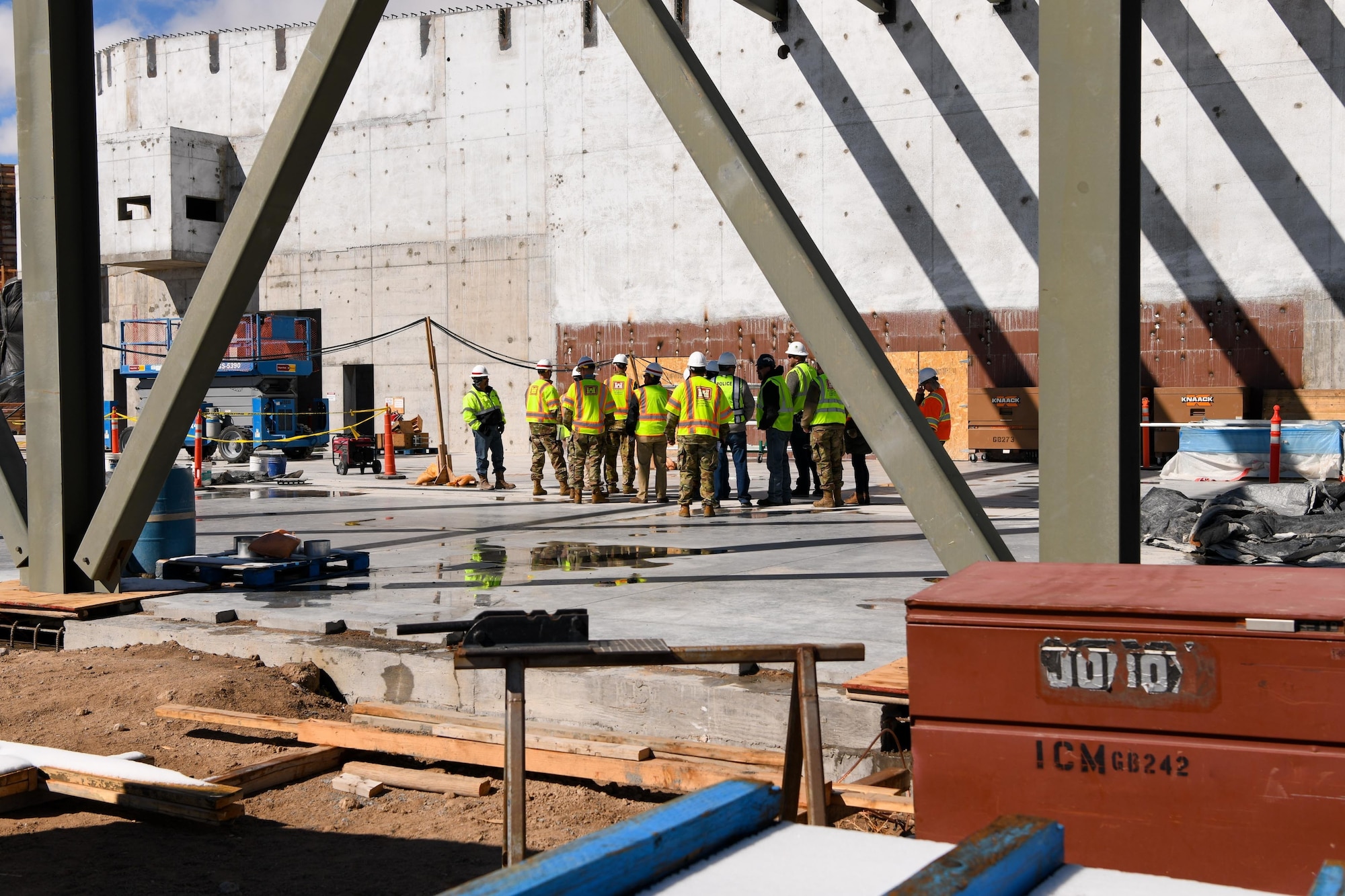 A group in visibility vests tours a construction site