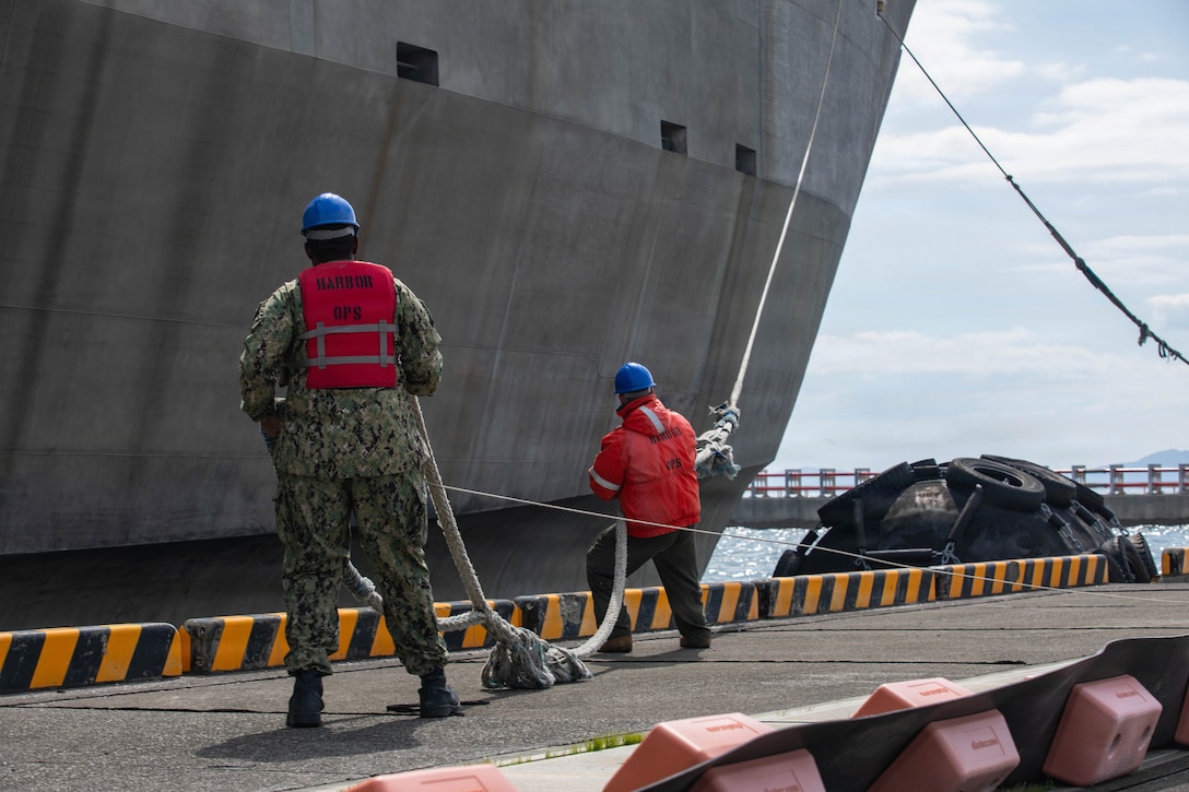 U.S. Navy Boatswain's Mate 2nd class Bo Naugle, right, a native of Illinois, and Electrician's Mate 3rd Class Terrell Smith, a native of Virginia, both with Headquarters and Headquarters Squadron (HHS), Marine Corps Air Station Iwakuni, pull rope from the U.S. Naval Ship Guam (T-HST 1) at Marine Corps Air Station Iwakuni, Japan, March 8, 2026. The U.S. Navy’s Military Sealift Command high-speed transport ship Guam docked at MCAS Iwakuni in support of Korea Marine Exercise Program 26.1. (U.S. Marine Corps photo by Lance Cpl. Siwan Lewis)