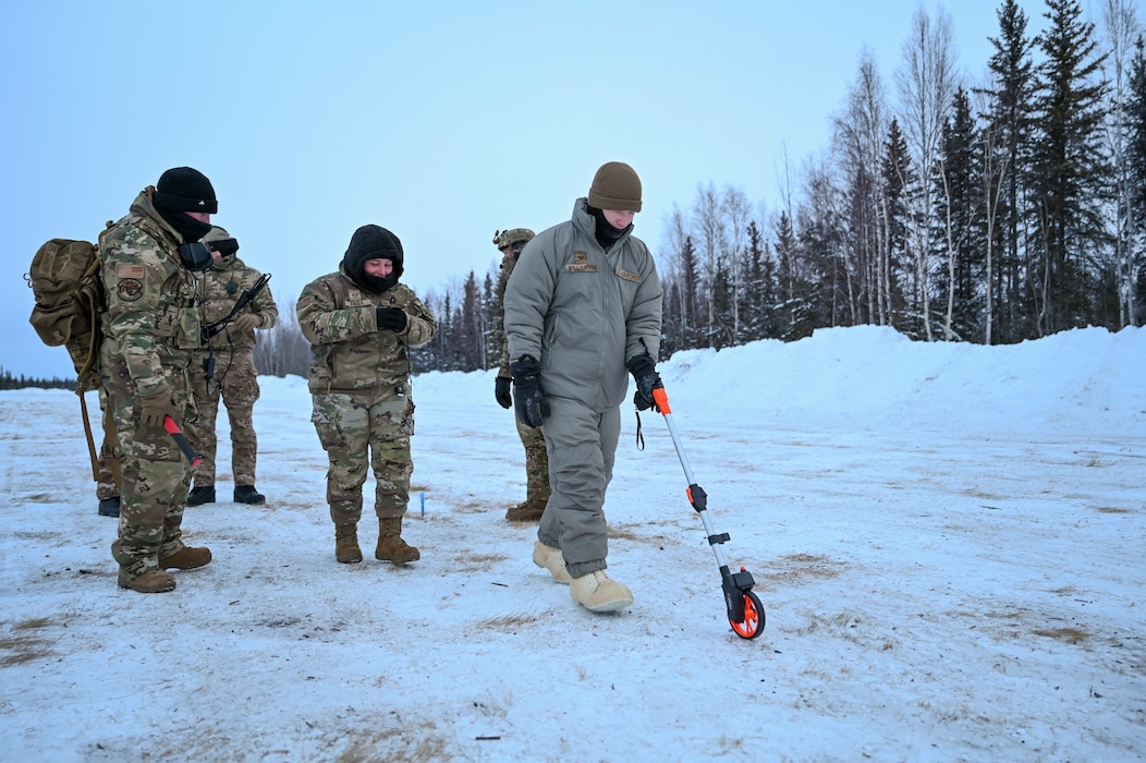 U.S. Air Force Staff Sgt. Brady Williamson, 354th Operations Support Squadron air traffic control watch supervisor, uses a measuring wheel to determine the dimensions of a landing zone during a training exercise at Eielson Air Force Base, Alaska, Feb. 17, 2026.