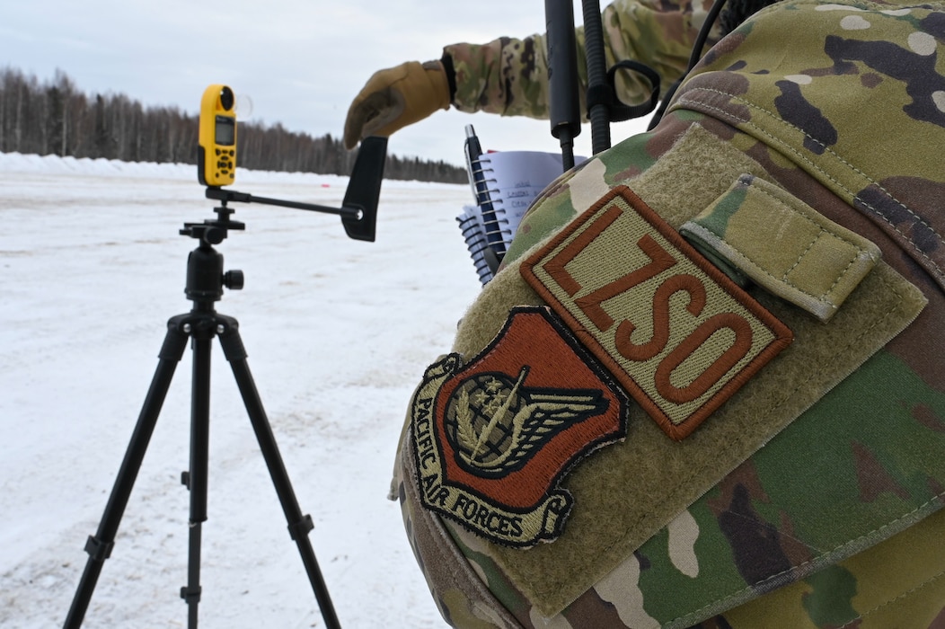 U.S. Air Force Staff Sgt. Rebecca Faulk, 354th Operations Support Squadron radar, airfield, & weather systems NCOIC, checks the wind speed on a wind and weather meter during a landing zone operation training at Eielson Air Force Base, Alaska, Feb. 17, 2026.