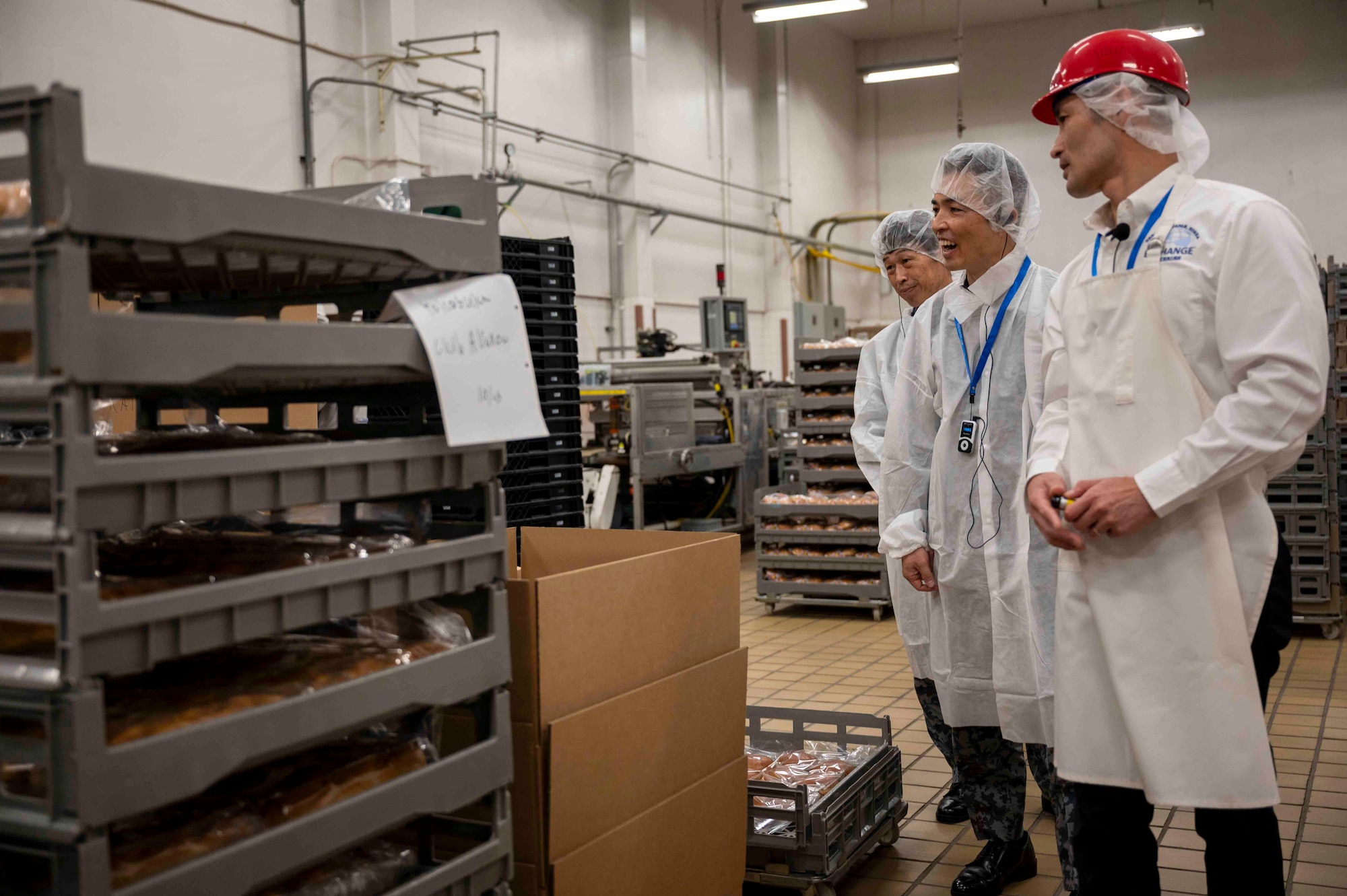 An AAFES worker gives a tour of a facility to Japan Air Self-Defense Force members.