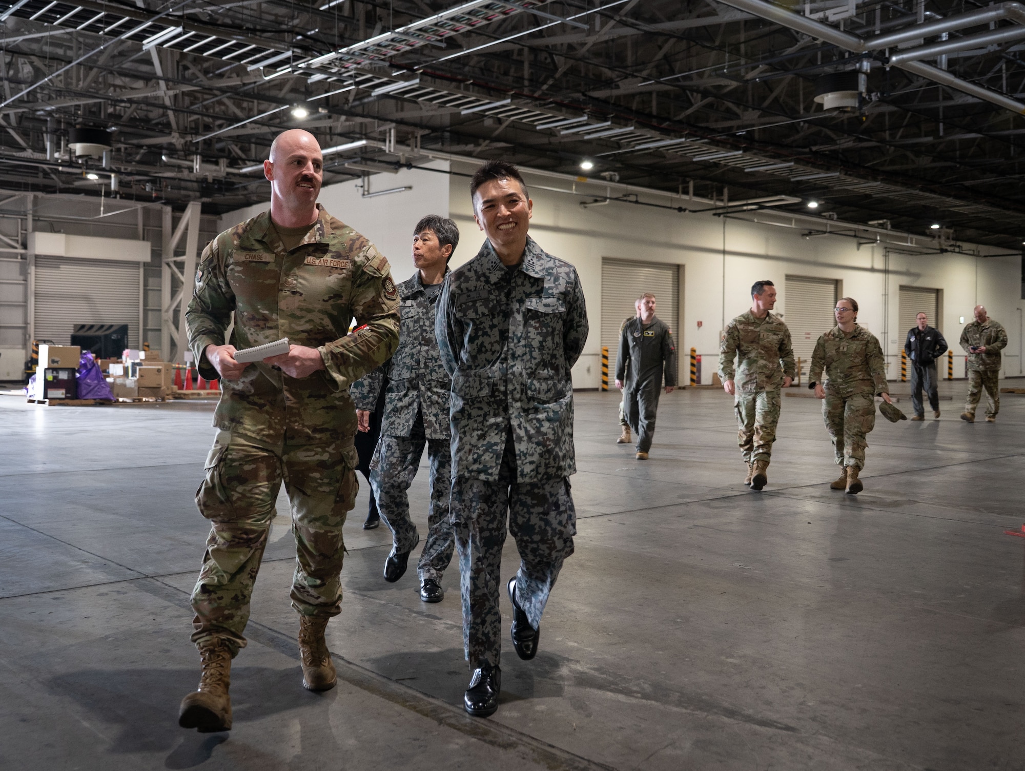 A U.S. Air Force Airman gives a tour of a building to Japan Air Self-Defense Force military members.