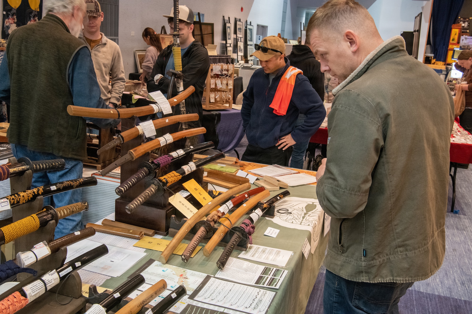 Shoppers look at swords for purchase.