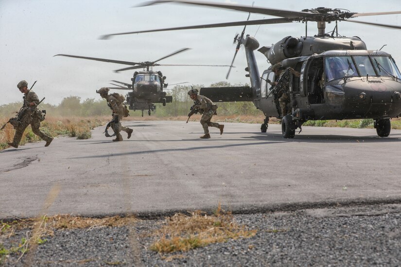 Soldiers from 5th Battalion, 20th Infantry Regiment, 1-2 Stryker Brigade Combat Team, 7th Infantry Division exit UH-60 Black Hawks during Military Operations in Urban Terrain (MOUT) training, March 14, 2026, at the Special Warfare Training Center in Lop Buri, Thailand.