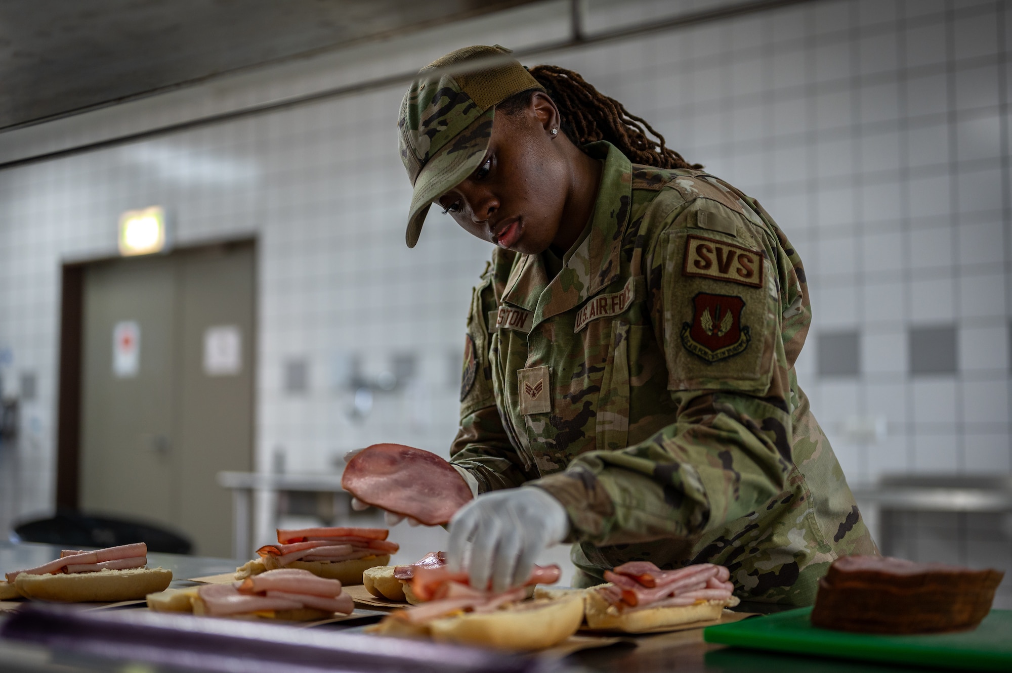 U.S. Air Force Senior Airman Kamiah Johnston, 786th Force Support Squadron food service journeyman, assembles sandwiches in the Jawbone Flight Kitchen at Ramstein Air Base, Germany, March 10, 2026. Located near the flightline, the kitchen provides boxed meals for a range of operations, including aeromedical evacuation missions, passenger transport and aircrew travelling through the installation. (U.S. Air Force photo by Senior Airman Jared Lovett)