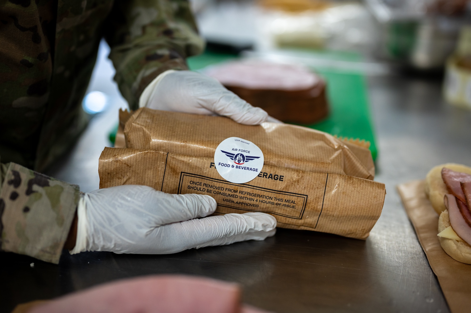 U.S. Air Force Senior Airman Kamiah Johnston, 786th Force Support Squadron food service journeyman, tapes a sandwich bag shut in the Jawbone Flight Kitchen at Ramstein Air Base, Germany, March 10, 2026. The Jawbone Flight Kitchen prepares a range of meals designed to travel well on aircraft and accommodate dietary needs. (U.S. Air Force photo by Senior Airman Jared Lovett)