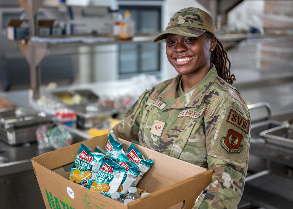 U.S. Air Force Senior Airman Kamiah Johnston, 786th Force Support Squadron food service journeyman, poses for a photo in the Jawbone Flight Kitchen at Ramstein Air Base, Germany, March 10, 2026. The Jawbone Flight Kitchen is manned 24/7 by four Airmen who work in shifts to ensure that aircrews receive the food supplies they need to keep the mission going. (U.S. Air Force photo by Senior Airman Jared Lovett)