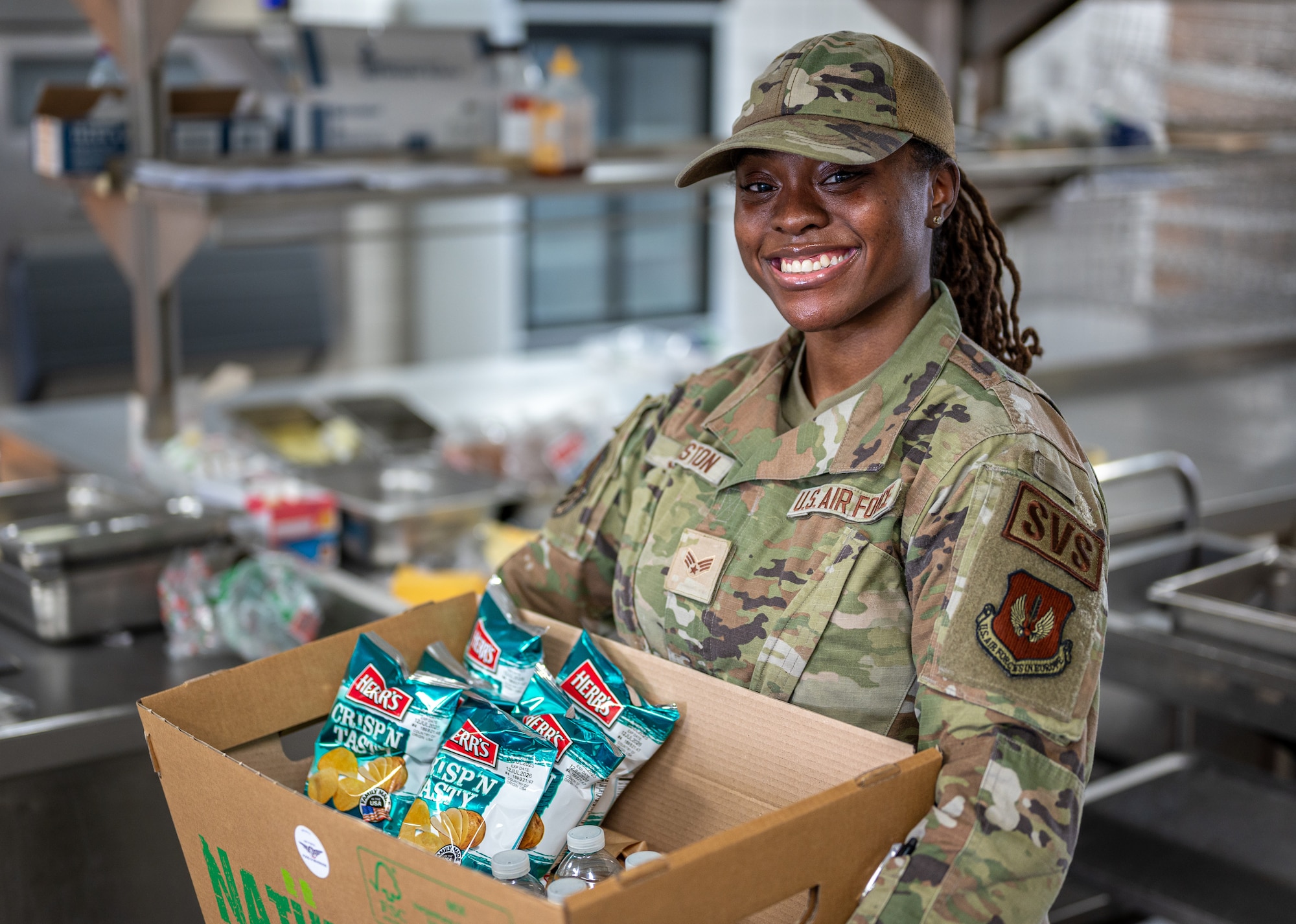 U.S. Air Force Senior Airman Kamiah Johnston, 786th Force Support Squadron food service journeyman, poses for a photo in the Jawbone Flight Kitchen at Ramstein Air Base, Germany, March 10, 2026. The Jawbone Flight Kitchen is manned 24/7 by four Airmen who work in shifts to ensure that aircrews receive the food supplies they need to keep the mission going. (U.S. Air Force photo by Senior Airman Jared Lovett)