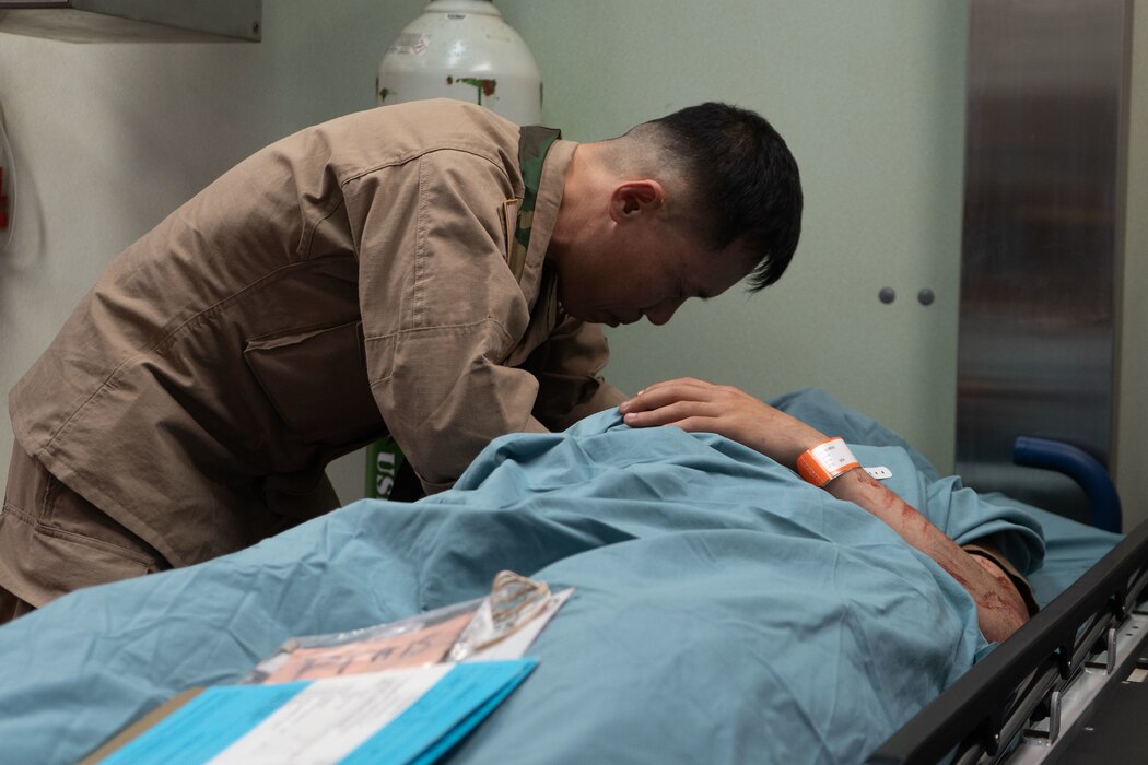 Lt. Hyun Namkung, a chaplain assigned to the Mercy-class hospital ship USNS Comfort (T-AH 20), participates in a mass casualty exercise by praying over a mock casualty during Continuing Promise 2025, June 1, 2025.