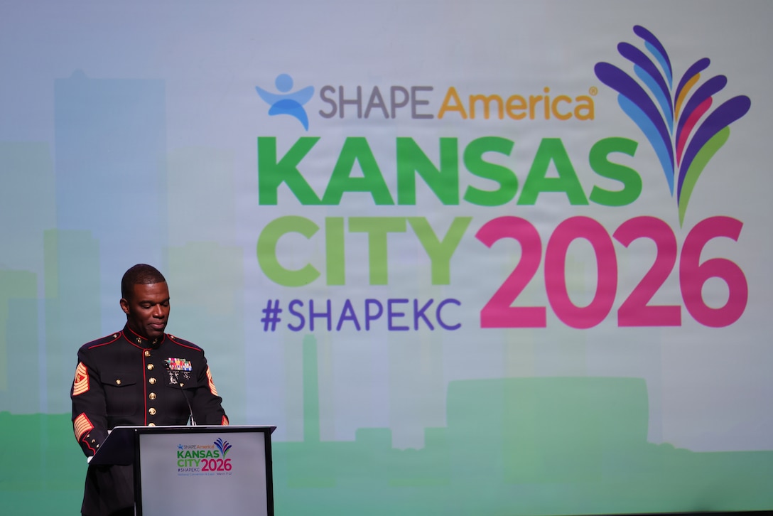 U.S. Marine Corps Master Gunnery Sgt. Louis Vickers II, the Career Counselor Course Chief with Recruiting and Retention School, Marine Corps Recruit Depot San Diego, speaks at the opening general session of the Society of Health and Physical Educators Partnership convention in Kansas City, Mo., March 17, 2026.


 The SHAPE convention recognizes the work that is essential in building physically and mentally fit youth who are resilient and have the necessary skill to succeed in life. 


(U.S. Marine Corps photo by Staff Sgt. Joseph Drewsen)