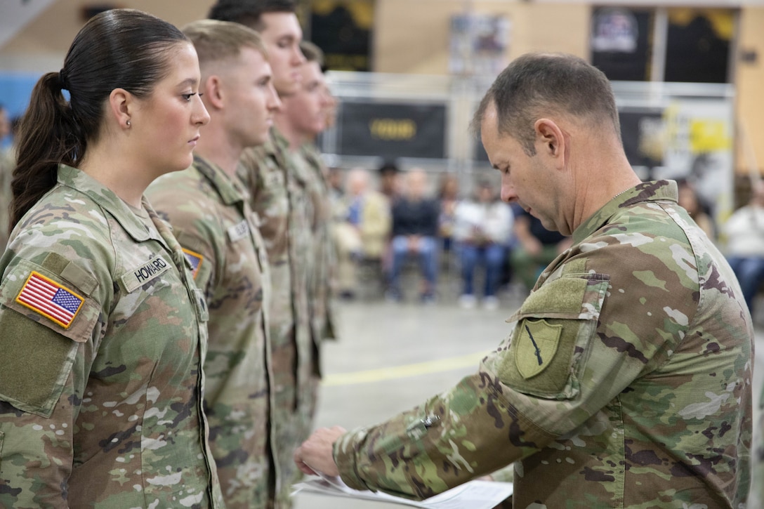 U.S. Army Command Sgt. Maj. Jesse Withers, Kentucky's state command sergeant major, presents a check to Spc. Isabella Howard during a ceremony at Boone National Guard Center in Frankfort, Nov. 19, 2025. The presentation is part of the Kentucky Enlistment Enhancement Program, an initiative that pays Soldiers for enlistments that they refer to the Guard. (U.S. Army National Guard photo by Milt Spalding)