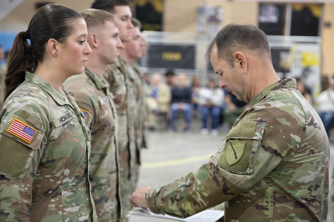 U.S. Army Command Sgt. Maj. Jesse Withers, Kentucky's state command sergeant major, presents a check to Spc. Isabella Howard during a ceremony at Boone National Guard Center in Frankfort, Nov. 19, 2025. The presentation is part of the Kentucky Enlistment Enhancement Program, an initiative that pays Soldiers for enlistments that they refer to the Guard. (U.S. Army National Guard photo by Milt Spalding)