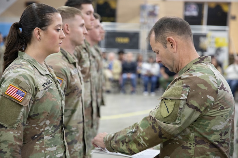 U.S. Army Command Sgt. Maj. Jesse Withers, Kentucky's state command sergeant major, presents a check to Spc. Isabella Howard during a ceremony at Boone National Guard Center in Frankfort, Nov. 19, 2025. The presentation is part of the Kentucky Enlistment Enhancement Program, an initiative that pays Soldiers for enlistments that they refer to the Guard. (U.S. Army National Guard photo by Milt Spalding)
