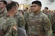 U.S. Army Command Sgt. Maj. Jesse Withers, Kentucky's state command sergeant major, presents a check to Pfc. Iram Sosa during a ceremony at Boone National Guard Center in Frankfort, Nov. 19, 2025. The presentation is part of the Kentucky Enlistment Enhancement Program, an initiative that pays Soldiers for enlistments that they refer to the Guard. (U.S. Army National Guard photo by Milt Spalding)