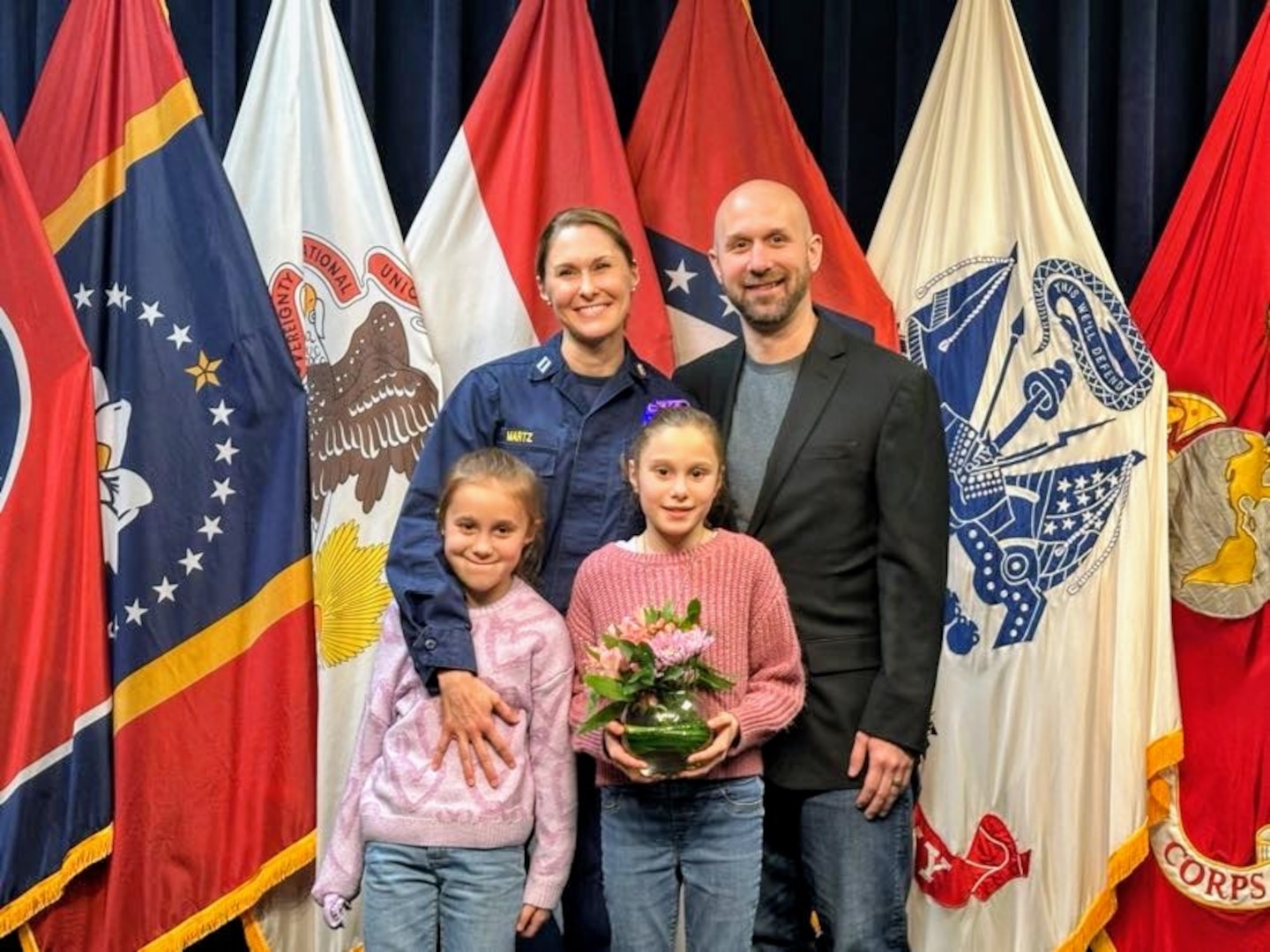 Lt. Amber Martz, a nurse practitioner with the USPHS Commissioned Corps, poses with her family after receiving a DAISY award. Martz serves as the first-ever USPHS officer within USMEPCOM.