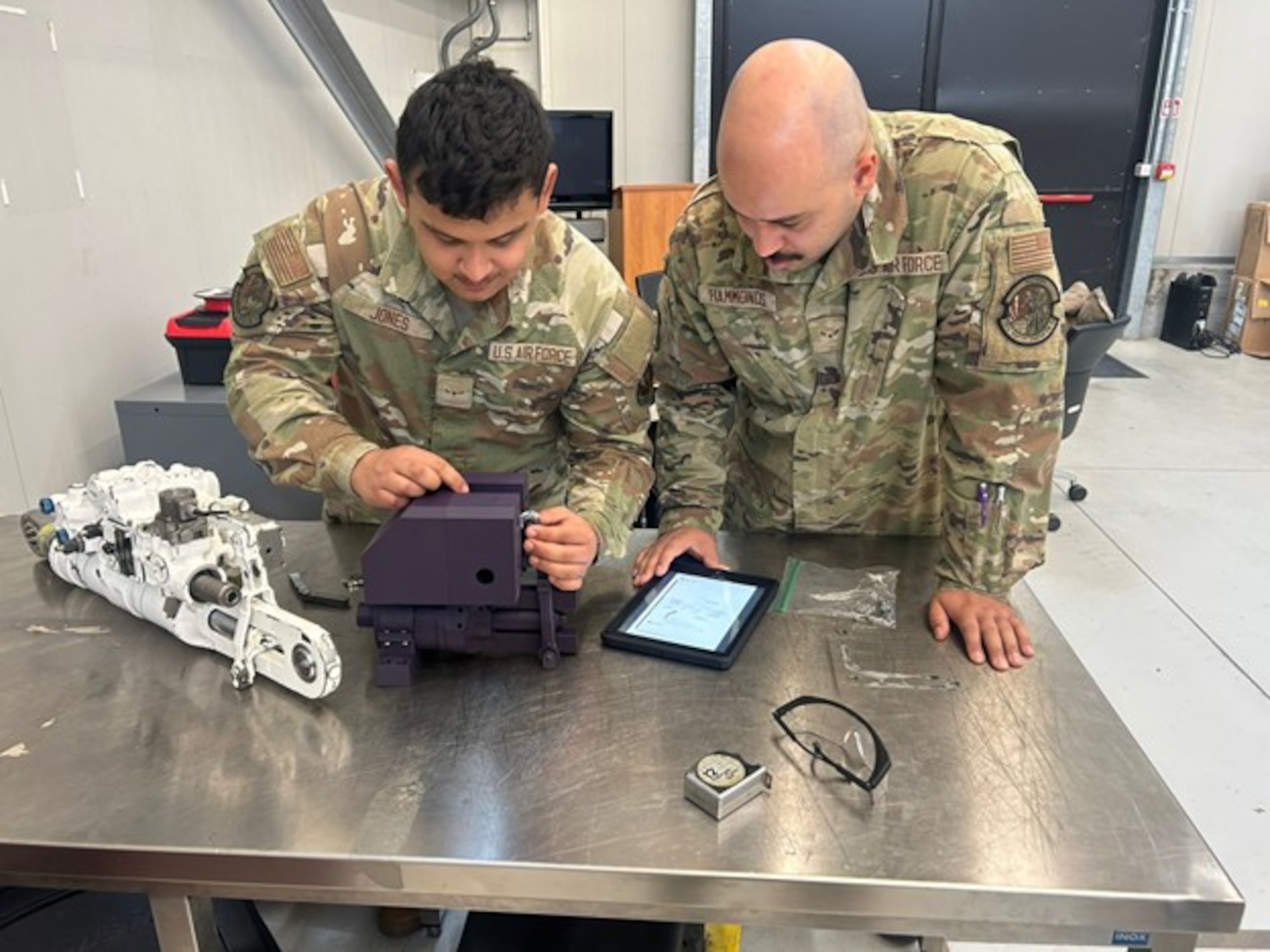 .S. Air Force Airman Anthony Jones and Airman 1st Class Jonathon Hammonds, 372nd Training Squadron/Detachment 224 aircraft maintenance students, operate a prototype 3D-printed Flap and Stabilizer Integrated Servo-Actuator (ISA)