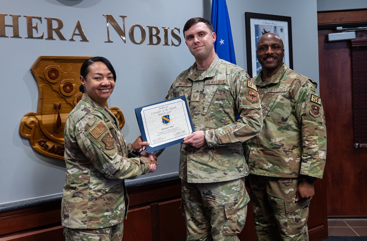 U.S. Air Force Col. Shamekia Toliver and Chief Master Sgt. Eric Adams, 42d Security Forces Squadron senior enlisted leader, present Staff Sgt. Daniel Miller, 42d Air Base Wing occupational and flight safety noncommissioned officer in charge, Crusader of the Month at Maxwell Air Force Base, Alabama, March 4, 2026.