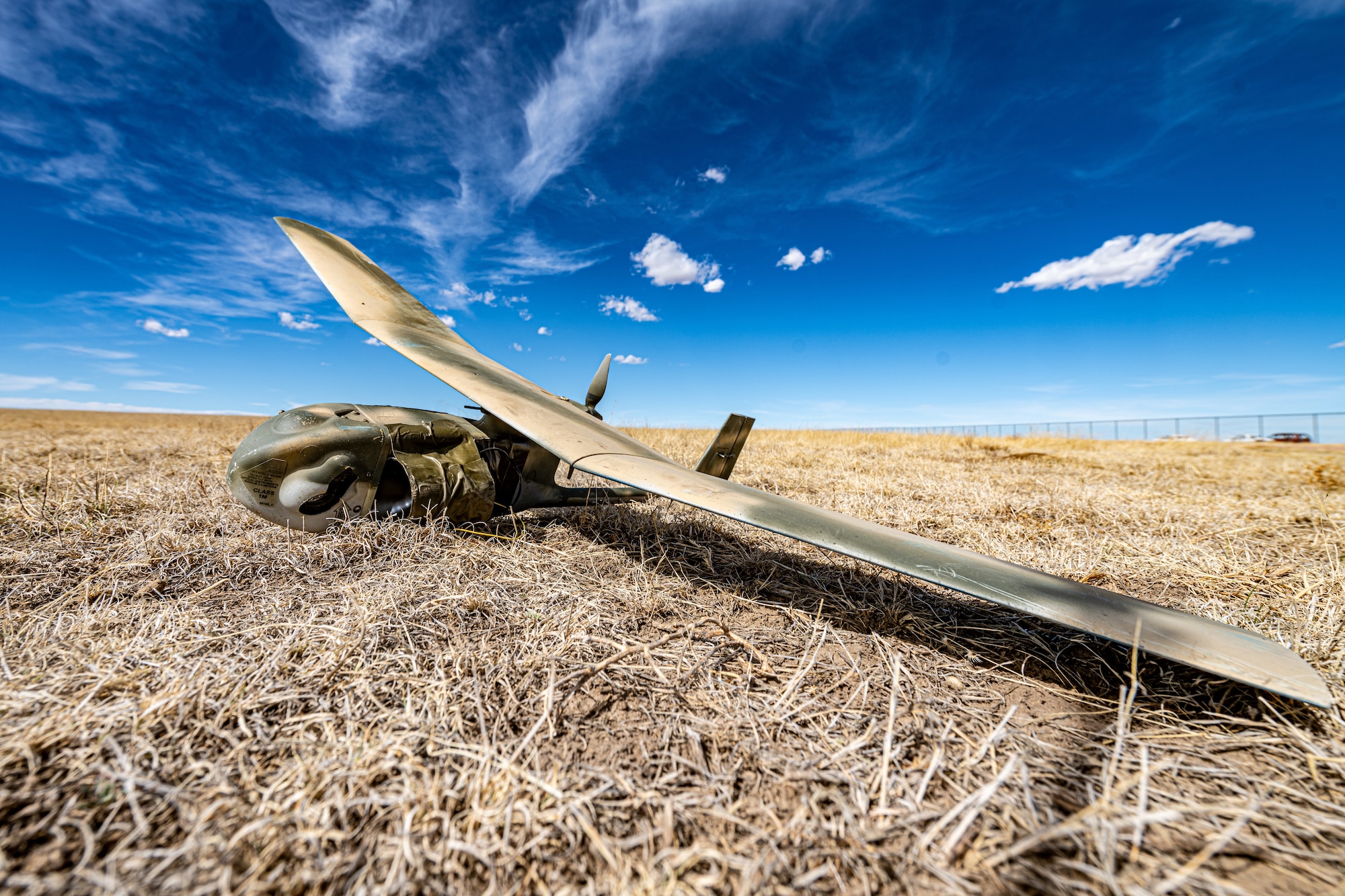 An unmanned aircraft system lies on the ground.