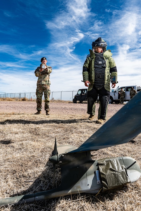 An EOD tech approaches a drone on the ground.