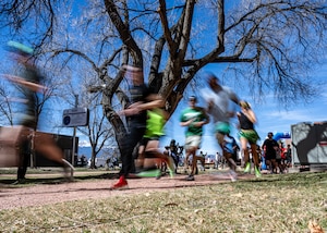 a group of runner pass by a sign.