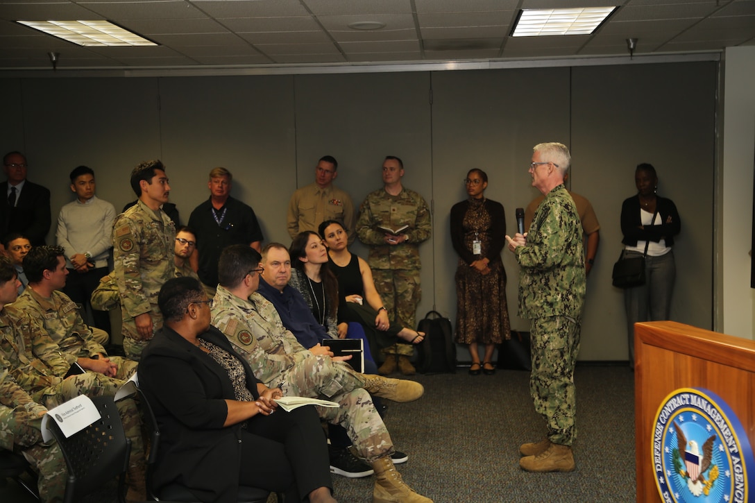 A man in a military uniform speaks to an audience