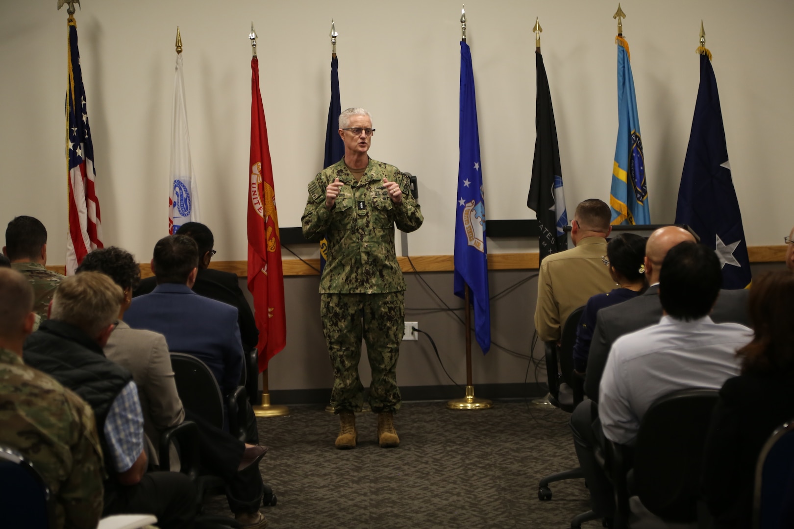 A man in a military uniform speaks to an audience