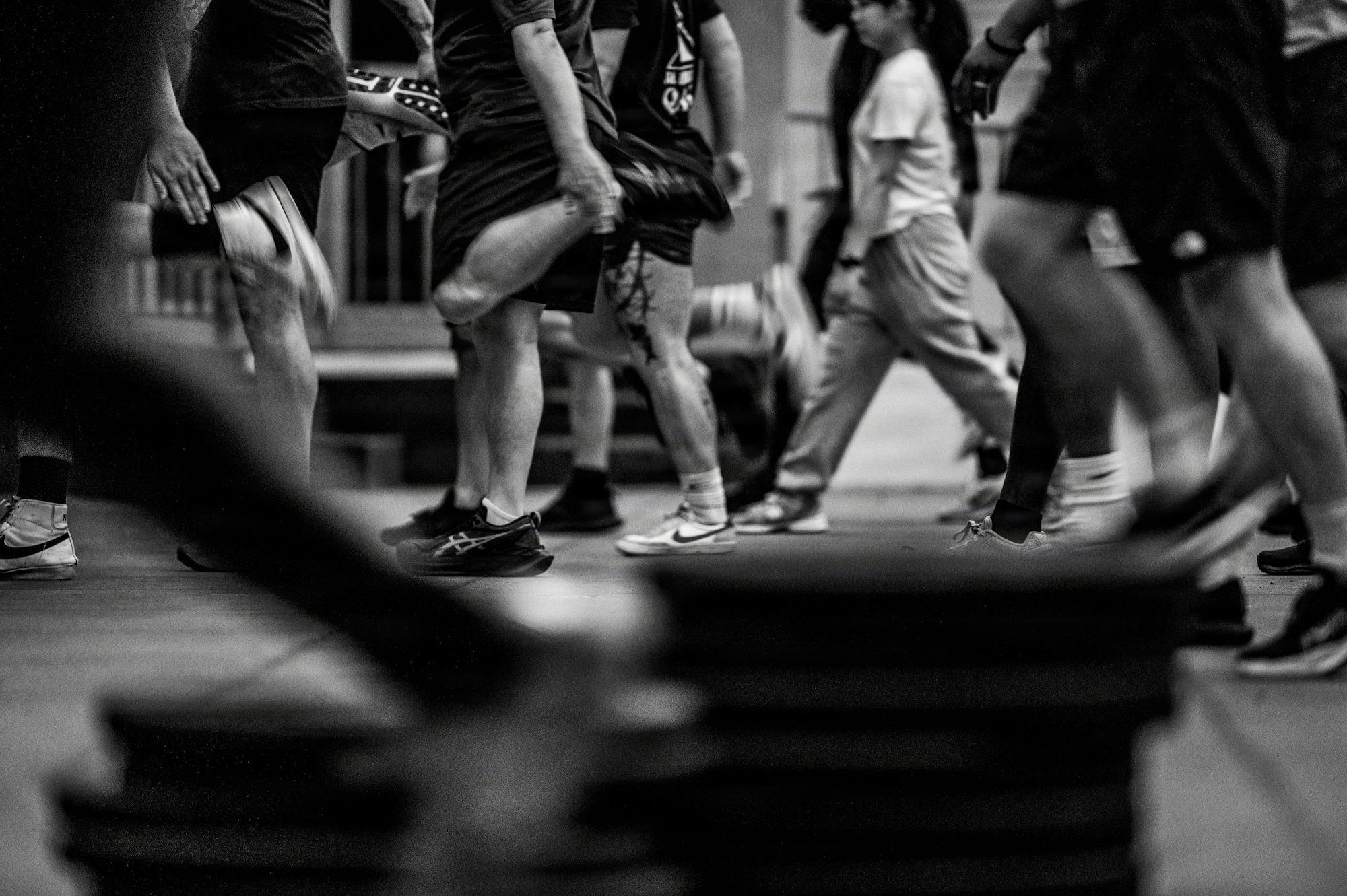 A zoomed in photo of multiple Airmen legs doing a warmup exercise.