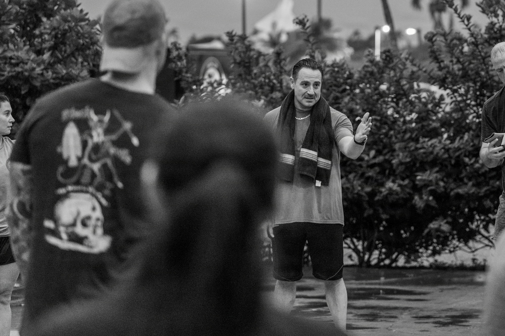 An Airman gives a speech to other Airmen in work-out clothes.