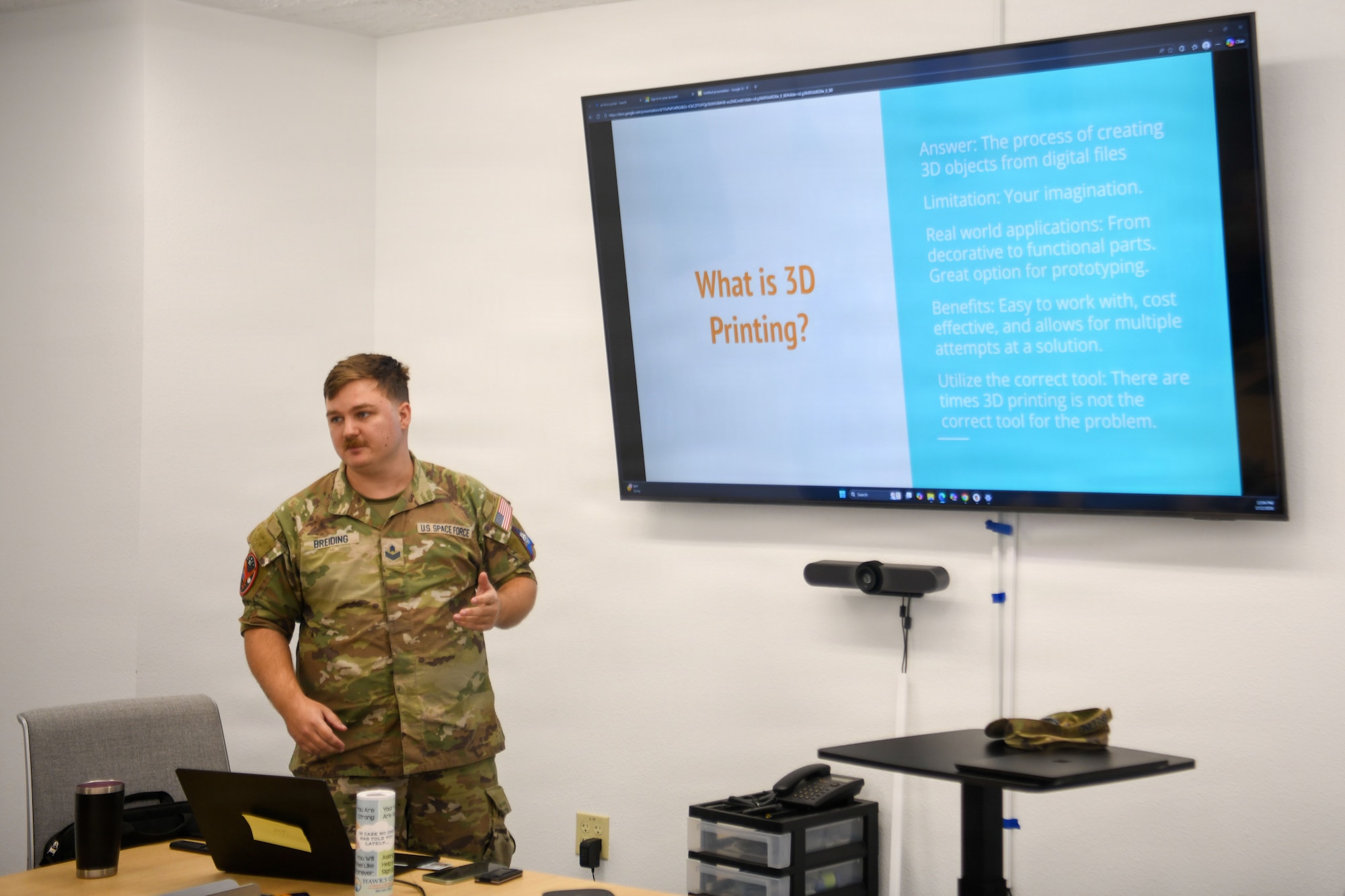 U.S. Space Force Sgt. Nicolas M. Breiding, Delta 2 Signals Intelligence Analysis noncommissioned officer in charge, stands in front of a screen.