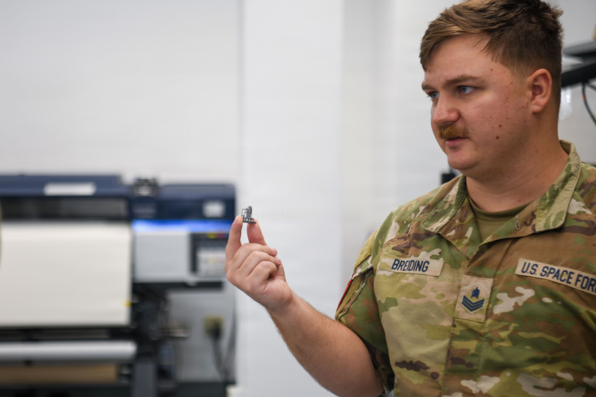 U.S. Space Force Sgt. Nicolas M. Breiding, Delta 2 Signals Intelligence Analysis noncommissioned officer in charge, holds an object in his hand during a demonstration.