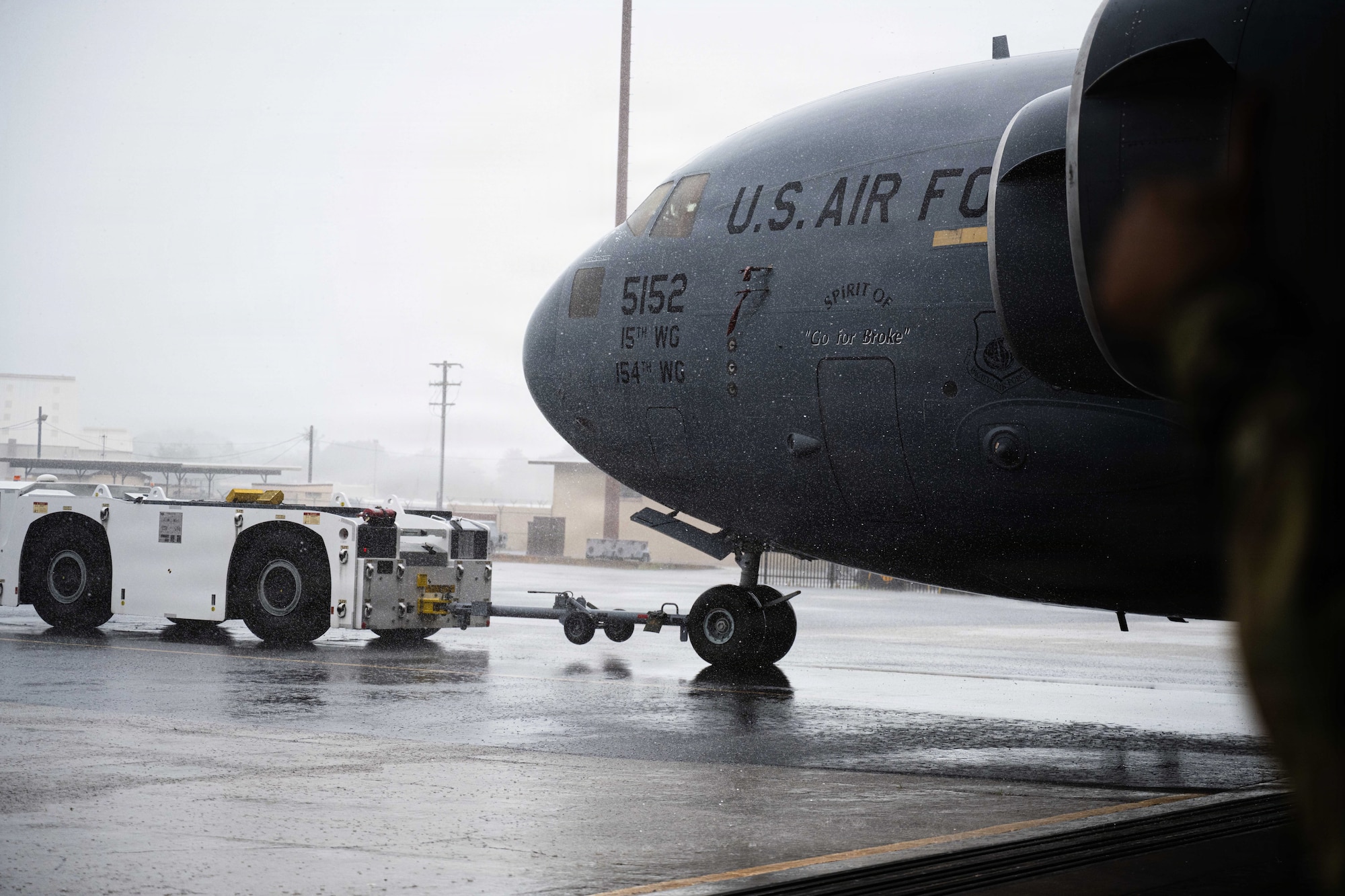 An U.S. Air Force aircraft is being towed by a large white truck.