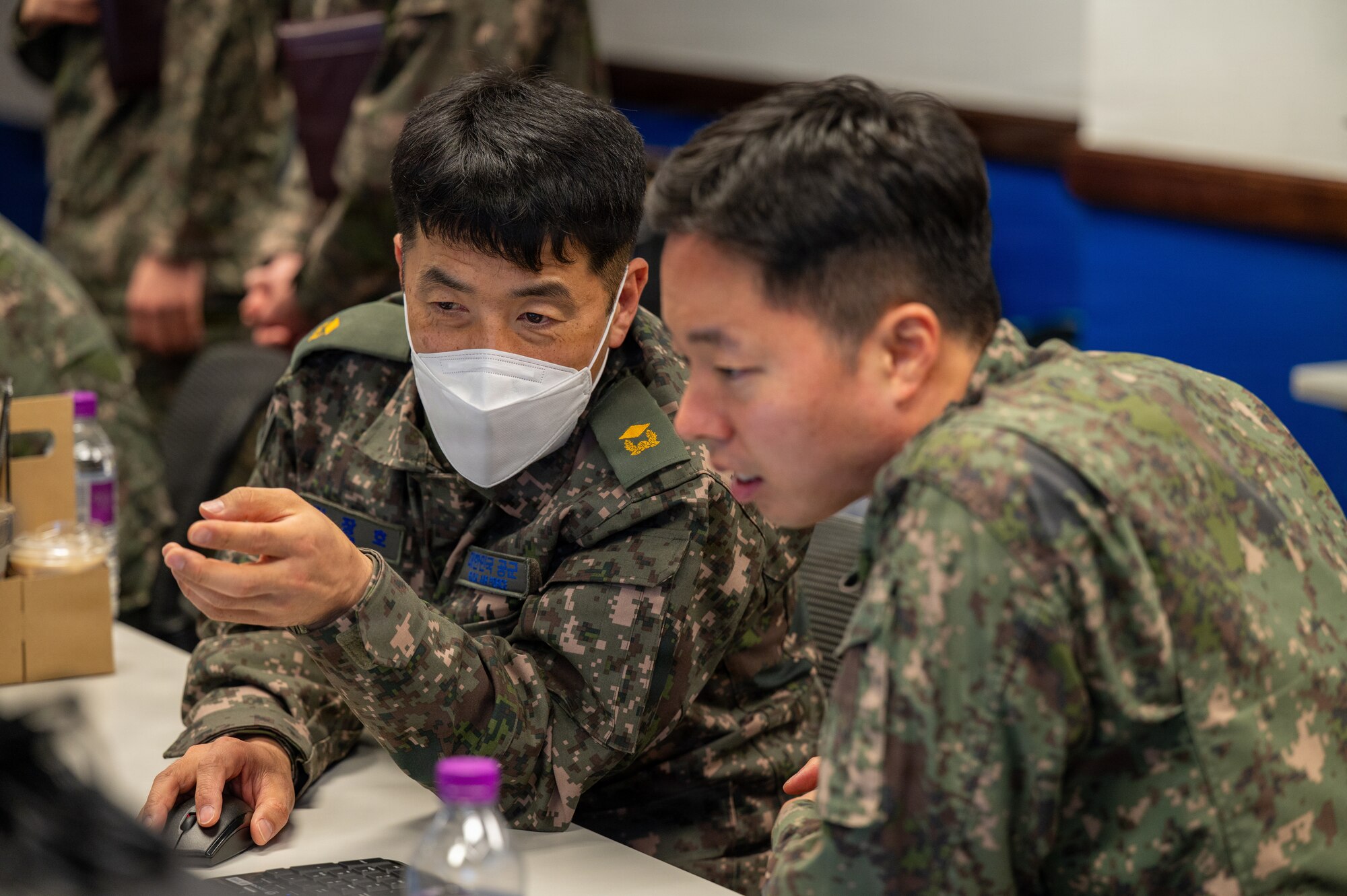 Republic of Korea air force Warrent Officer Kim Jangho, left, and Capt. Kim Banseok, right, Air Force Operations Center air defense guided weapon maintenance officers, discuss operations during exercise Freedom Shield 26 at Osan Air Base, Republic of Korea, March 10, 2026.