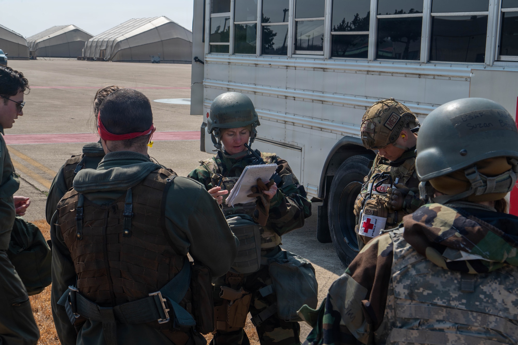 Airmen hold a planning meeting outside.