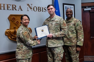 U.S. Air Force Col. Shamekia Toliver and Chief Master Sgt. Eric Adams, 42d Security Forces Squadron senior enlisted leader, present Staff Sgt. Daniel Miller, 42d Air Base Wing occupational and flight safety noncommissioned officer in charge, Crusader of the Month at Maxwell Air Force Base, Alabama, March 4, 2026.
