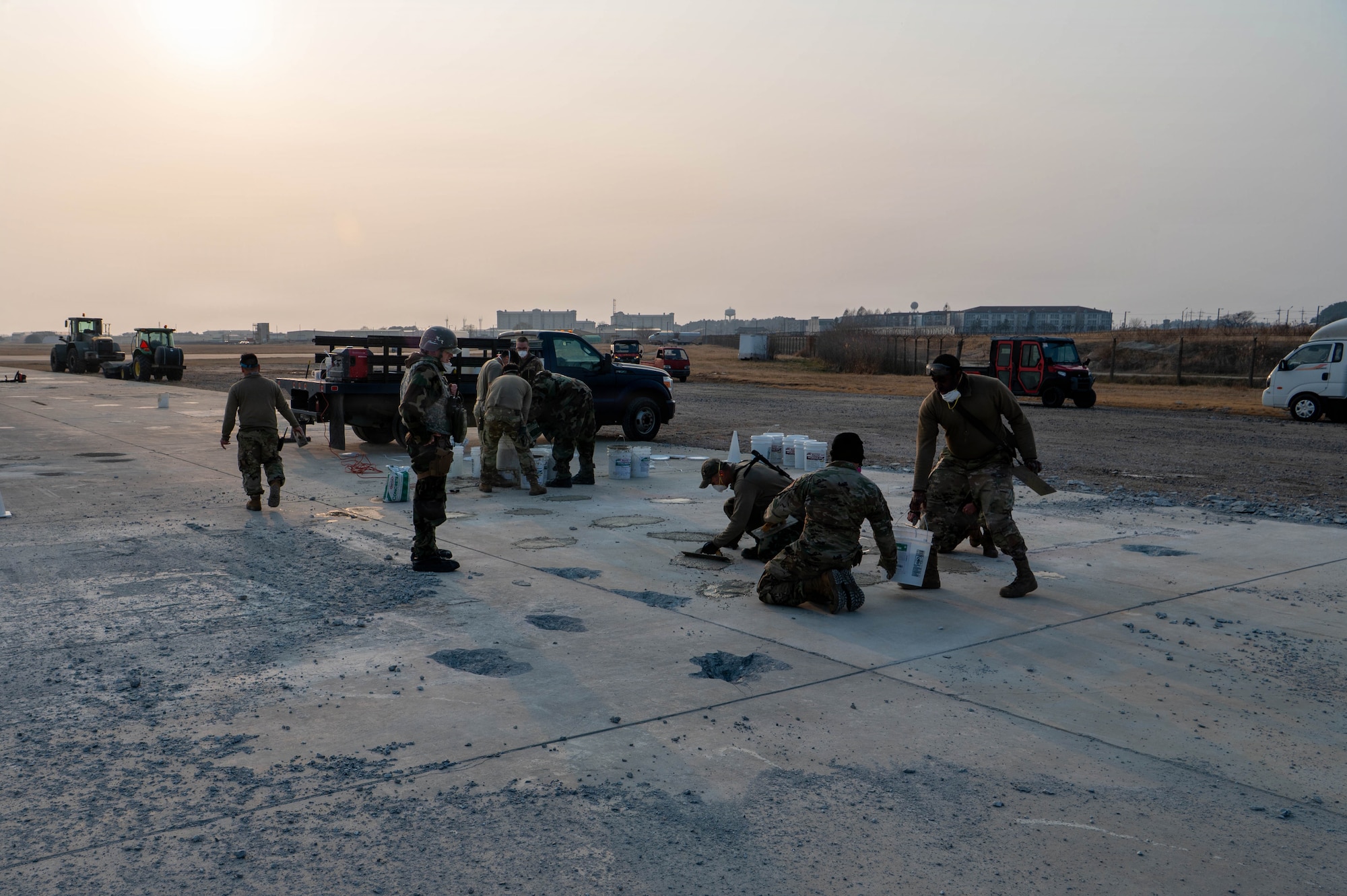 Airmen fill holes with concrete.