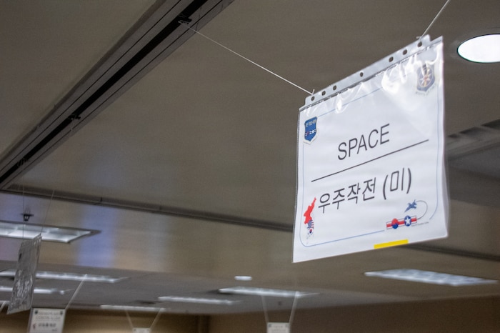 A space component sign hangs in the Pacific Air Simulation Center at Osan Air Base, Republic of Korea, March 10, 2026. The PASC’s space exercise control group leverages permanent party and surge forces to deliver round-the-clock simulated data. (U.S. Space Force photo by 1st Lt. Jimmy Nguyen)