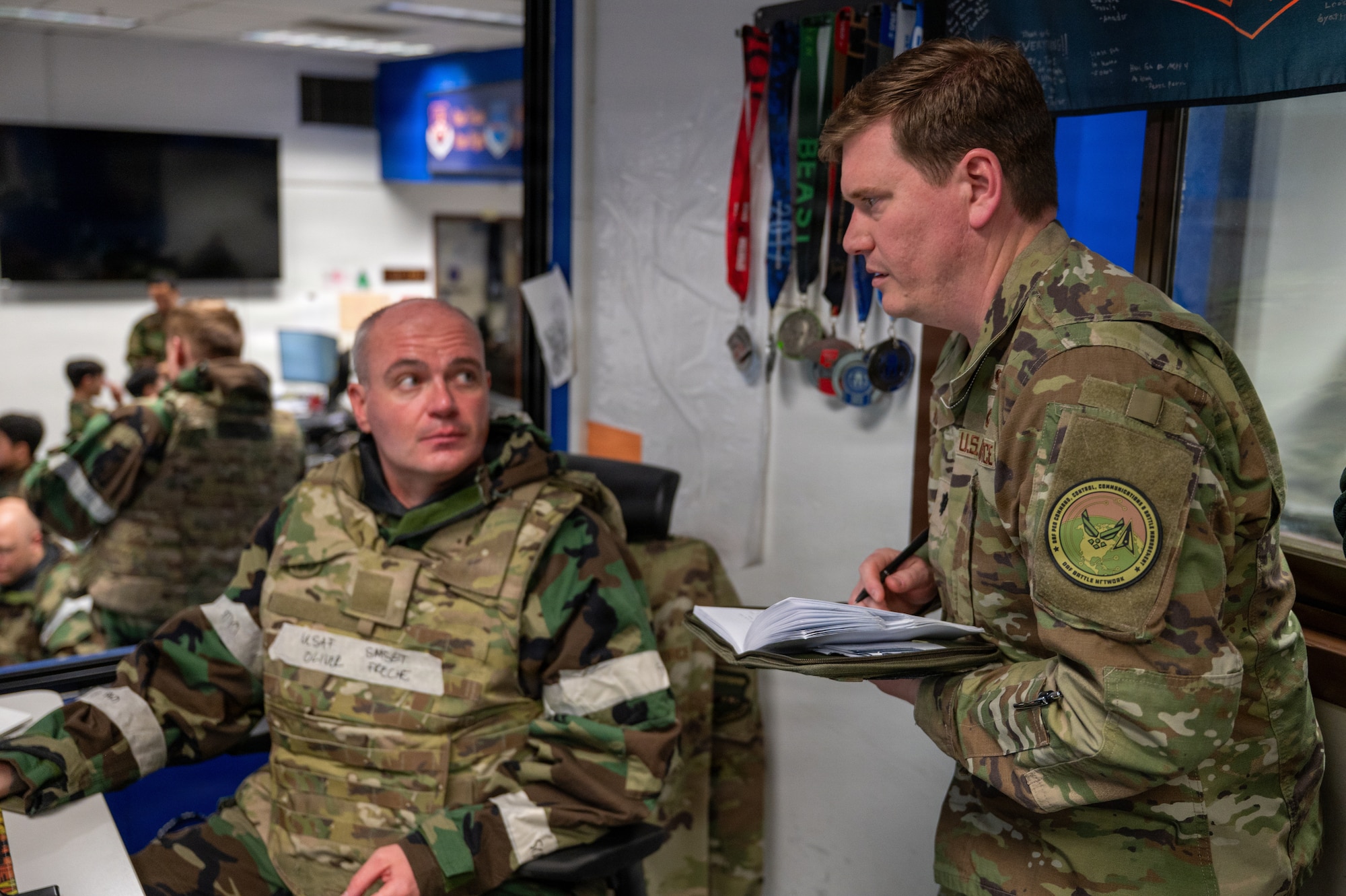 U.S. Air Force Senior Master Sgt. Oliver Freche, left, Seventh Air Force contingency fleet supervisor, and Lt. Col. Justin Raines, Kessel Run wing C2 branch chief, discuss operation conditions during exercise Freedom Shield 26 at Osan Air Base, Republic of Korea, March 11, 2026.