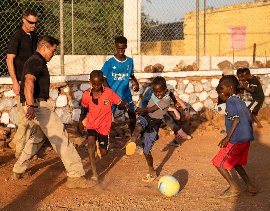 Lt. Col. Lawrence Melnicoff, 776th Expeditionary Air Base Squadron commander, plays soccer with children