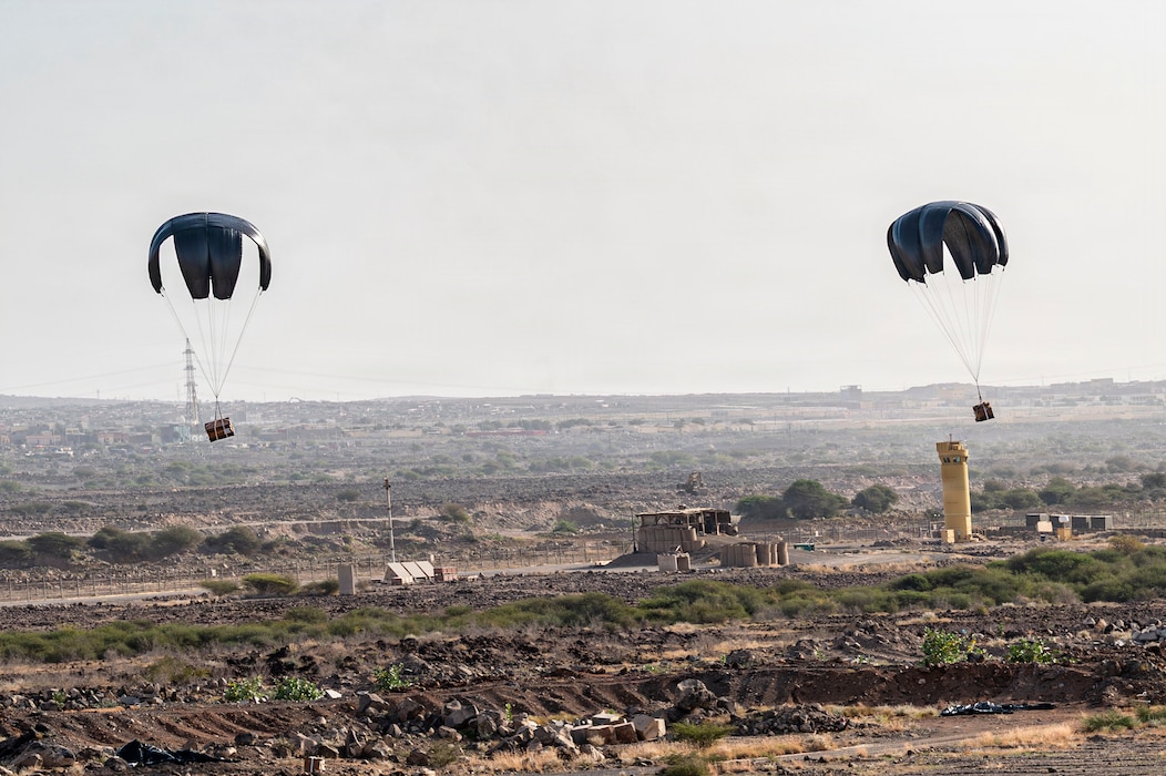 Two bundles of humanitarian supplies fall from the sky during a humanitarian mission